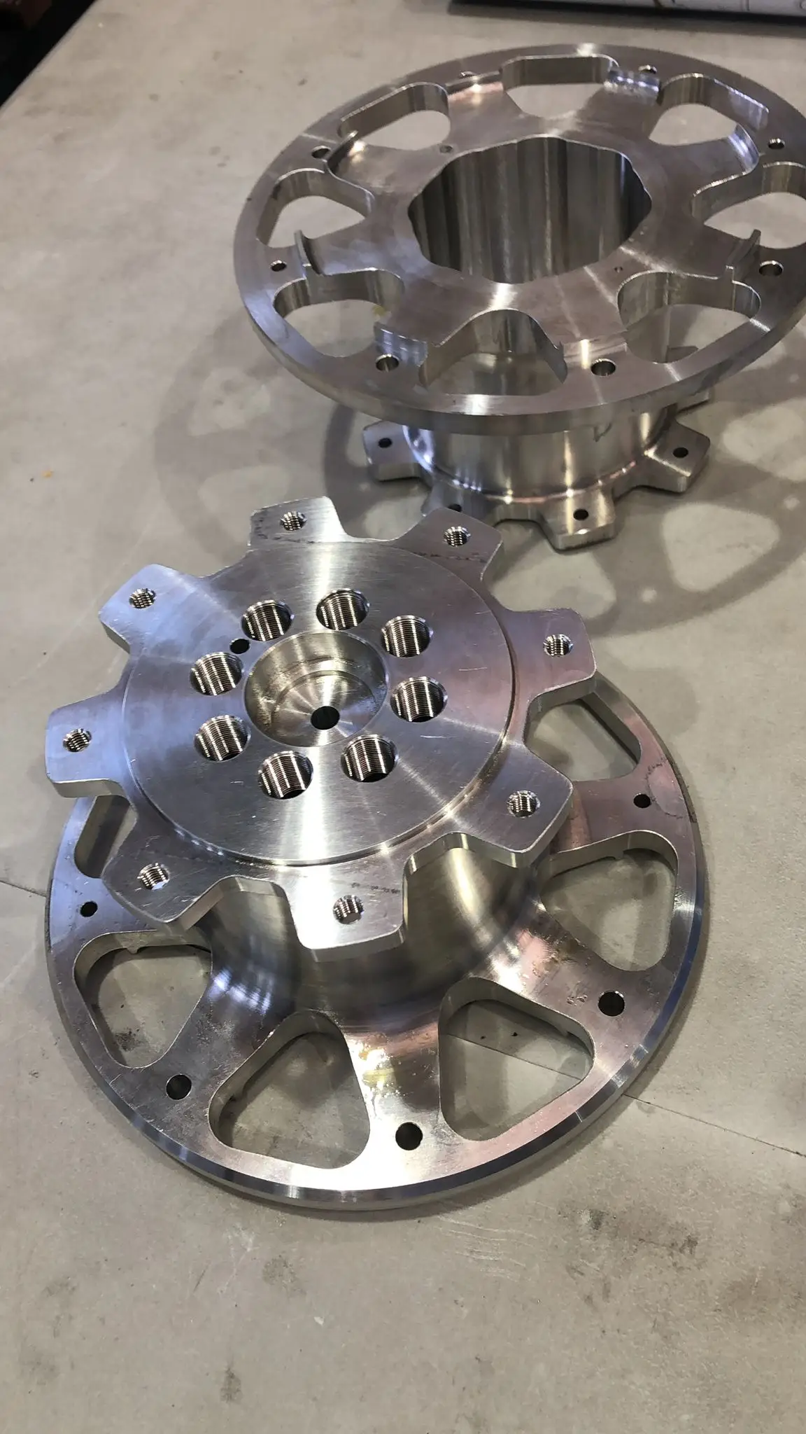 Two circular aluminium flanges, turned and milled, with radial lightening pockets and threaded holes