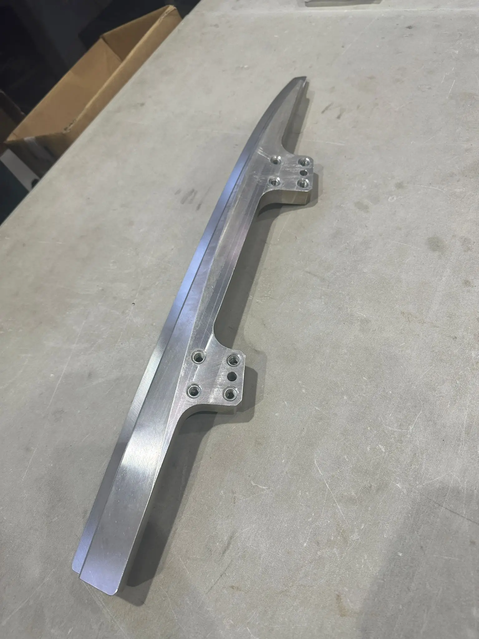 Curved aluminium bracket with milled seating faces and threaded inserts